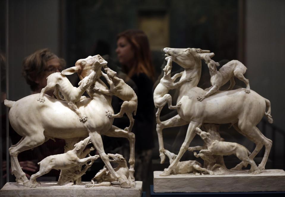 Visitors walks past marble sculptures of stags being attacked by hunting dogs, found in the ruins of ancient Roman town of Herculaneum, during a photo call for the upcoming exhibition entitled 'Life and death Pompeii and Herculaneum', in central London, Tuesday, March 26, 2013. The exhibition about the two Roman cities, buried by a catastrophic volcanic eruption of Mount Vezuvius in 79 AD, will run at the museum from March 28 to Sept. 29, 2013. (AP Photo/Lefteris Pitarakis)