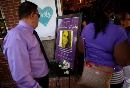 People walk past a picture of Heather Heyer, who was killed at in a far-right rally, as they arrive for her memorial service in Charlottesville, Virginia, U.S., August 16, 2017. REUTERS/Joshua Roberts