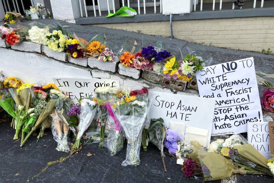 FILE - In this March 19, 2021, file photo, flowers, candles and signs are displayed at a makeshift memorial in Atlanta. A deadly rampage at three Georgia massage businesses, where the employees were mostly of Asian descent, has prompted Asian American women to openly share stories of being sexually harassed or demeaned based on their race. (AP Photo/Candice Choi, File)