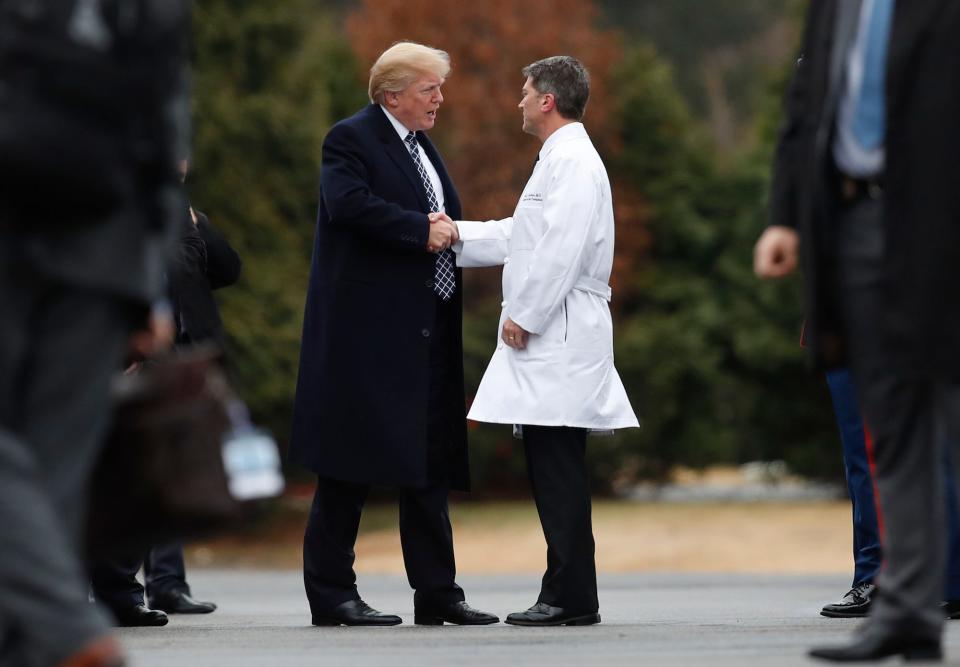 Donald Trump schüttelt die Hand von Ronny Jackson, dem Arzt im Weißen Haus während eines Teils seiner Präsidentschaft. - Copyright: Carolyn Caster/AP