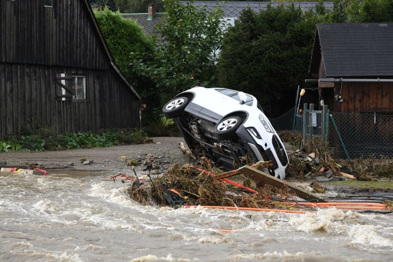 The flood wave of the river Bela has tipped a car onto its side. Peøina Ludìk/CTK/dpa