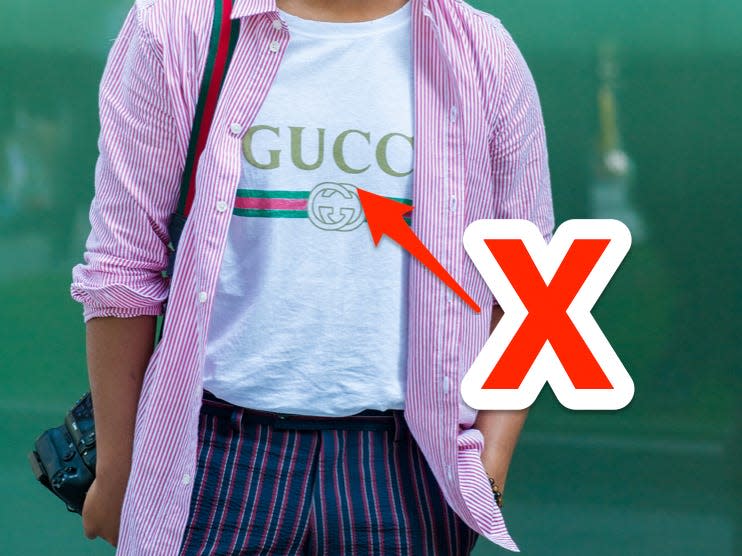 red x and arrow pointing at a gucci t-shirt someone is wearing under a pink button down