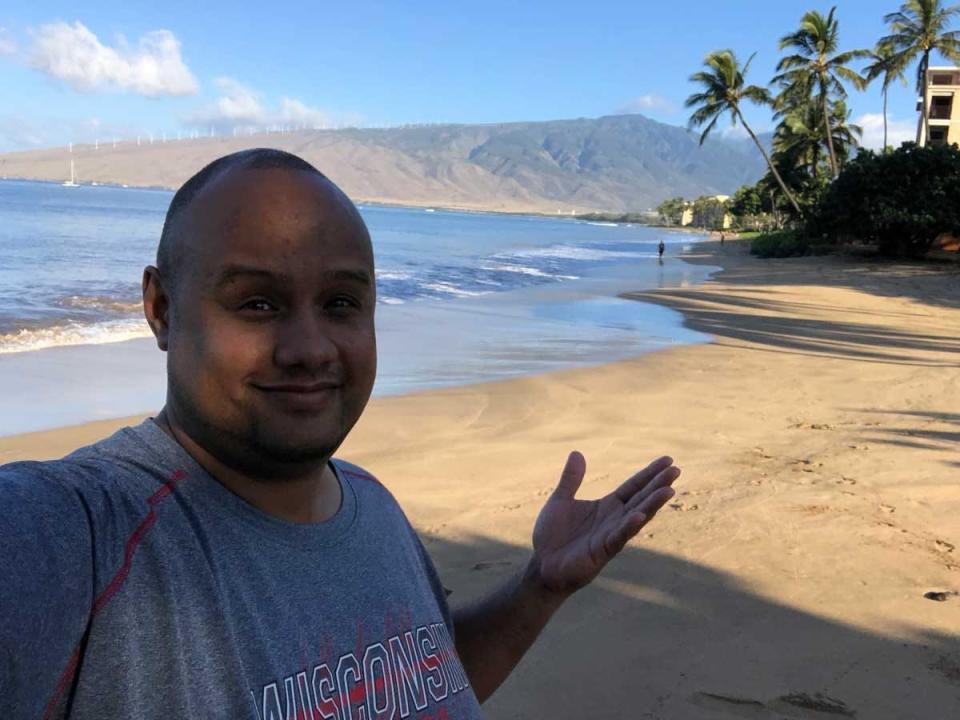 A man taking a selfie showing a tropical beach.