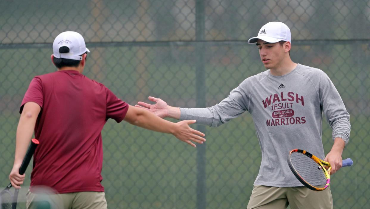 Walsh Jesuit's Michael Ulrich celebrates with Michael Vallone during a doubles tennis match against Brecksville on Wednesday.