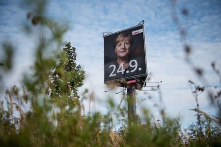 An election campaign poster for the upcoming general elections of the Christian Democratic Union party (CDU) with a headshot of German Chancellor Angela Merkel is displayed in Wustermark near Berlin, Germany, September 20, 2017. REUTERS/Stefanie Loos