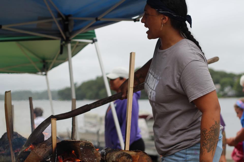 Taylor Harding Stasis, a member of the Herring Pond Wampanoag Tribe, carefully encourages the embers to burn during a mishoon burn the tribe is hosting in Plymouth. Daily visiting hours from noon to 4 p.m. are open to the public.