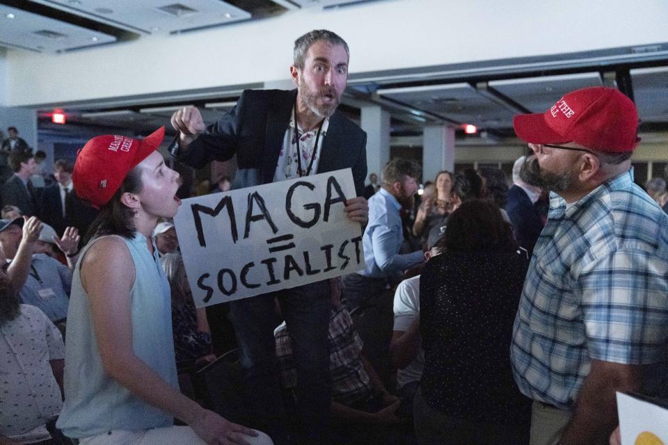 Libertarian delegate argue with Trump supporters as Republican presidential candidate former President Donald Trump speaks at the Libertarian National Convention at the Washington Hilton in Washington, Saturday, May 25, 2024. (AP Photo/Jose Luis Magana)