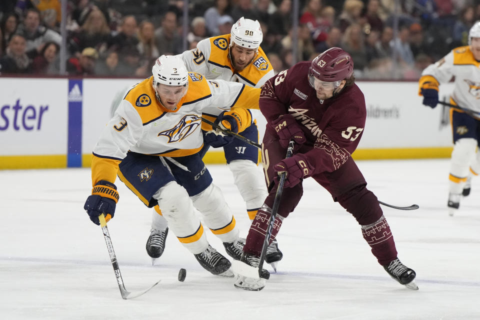 Nashville Predators defenseman Jeremy Lauzon (3) and center Ryan O'Reilly (90) and Arizona Coyotes left wing Matias Maccelli skate after the puck during the third period during an NHL hockey game Thursday, March 28, 2024, in Tempe, Ariz. (AP Photo/Rick Scuteri)