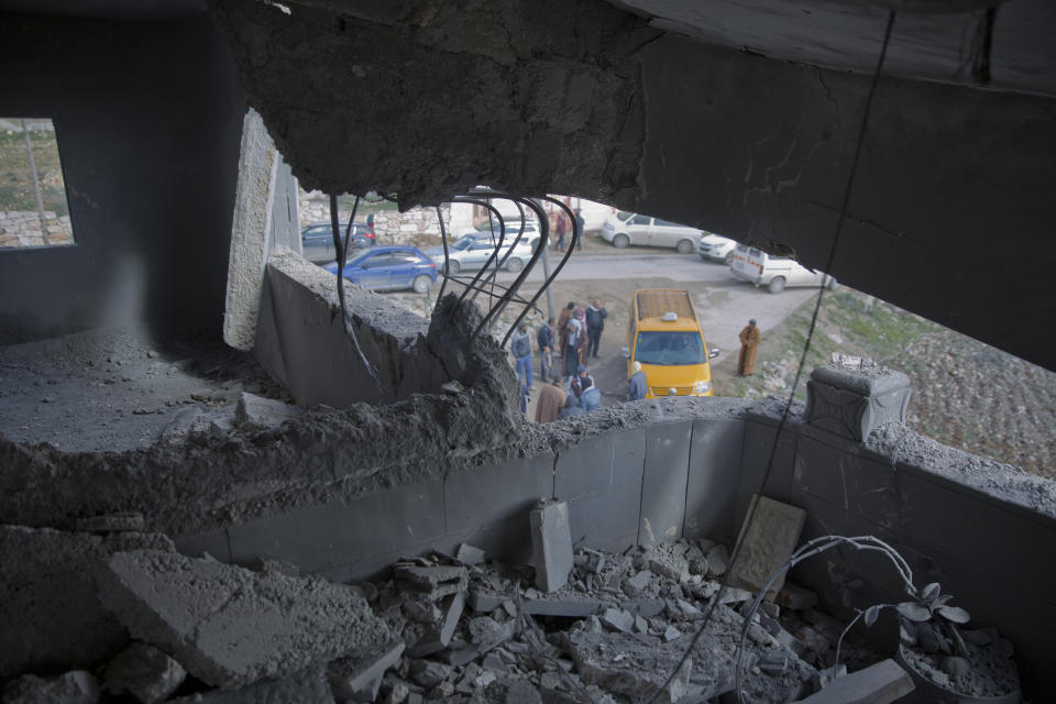 Palestinians gather by Khalil Jabarin's demolished apartment in the family house, in the West Bank village of Yatta, south of Hebron, Friday Jan. 18, 2019. Jabarin is charged with stabbing to death an Israeli in a West Bank settlement. (AP Photo/Nasser Nasser)