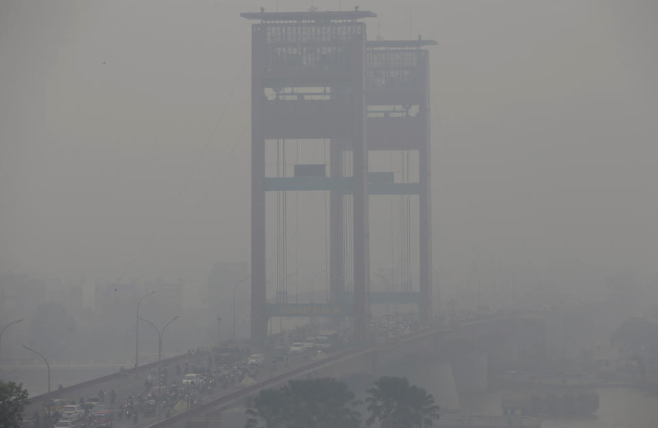 FILE - In this Sept. 19, 201, file photo, the vertical-lift Ampera Bridge spanning over the Musi River is shrouded by haze in Palembang, South Sumatra, Indonesia. Indonesia’s air quality has deteriorated from among the cleanest in the world to one of the most polluted over the past two decades, shaving five years from life expectancy in some regions, researchers say. (AP Photo/Tatan Syuflana, File)