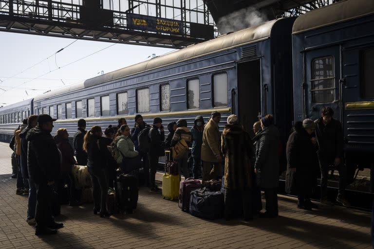 Los ucranianos que escapan de la ciudad sitiada de Mariupol junto con otros pasajeros de Zaporizhzhia se reúnen en el andén de una estación de tren tras llegar a Lviv, en el oeste de Ucrania, el domingo 20 de marzo de 2022. 