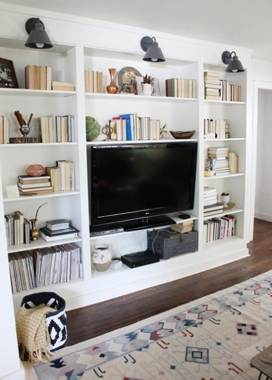 Add a wall of built-in bookshelves Few things say charm and character like built-ins. Take them floor-to-ceiling on an empty wall in your living space, dining room, or even hallway. To really boost the appeal, add sconces in between or over each shelf. Not only do built-ins create a beautiful focal point in your home, they also increase function. They’re perfect for book storage, but you could also get a set of pretty woven baskets to store and conceal items. You get more storage without compromising the tidy look of the shelves.