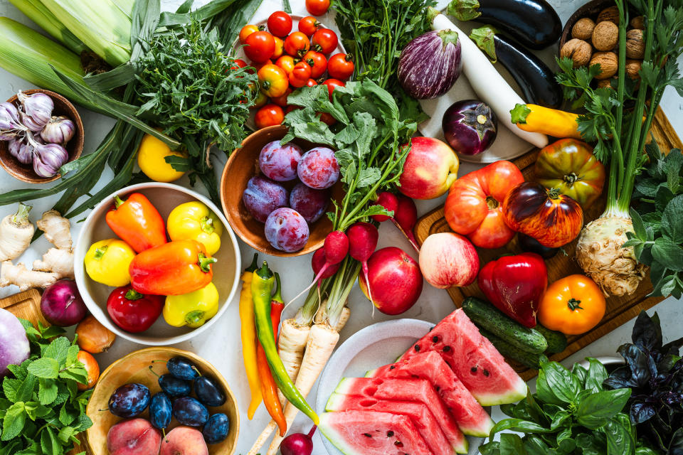 Assorted fresh fruits and vegetables spread out on a surface, highlighting variety and freshness