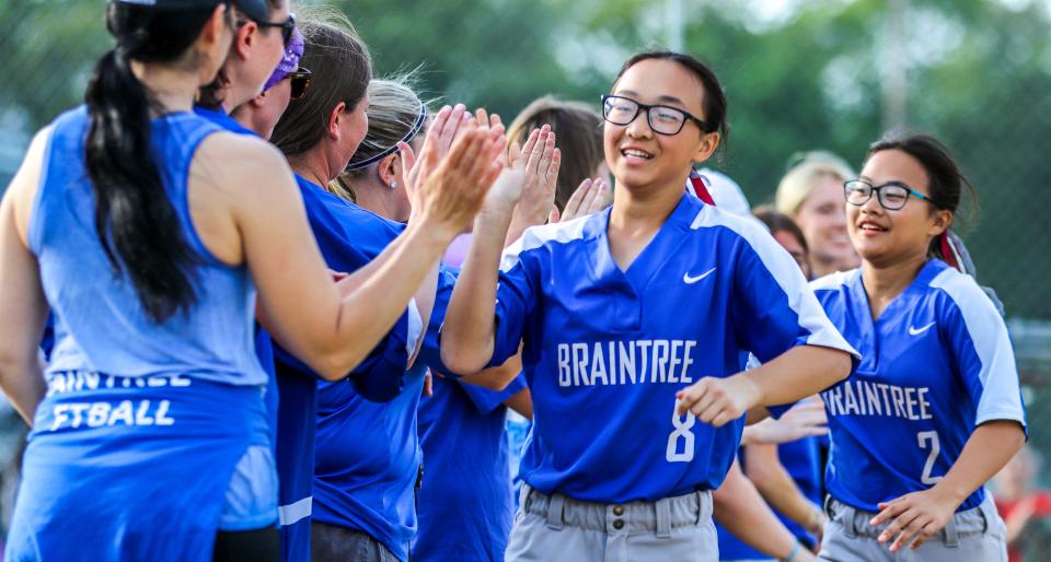 Braintree High's Catherine (8) and Jaclyn McPhee run through the line of high-fives during the "Hope at Bat" alumni game hosted by the Braintree High softball team on Friday, May 20, 2022.