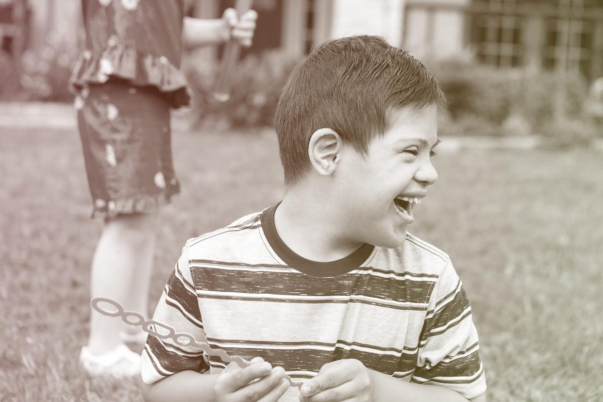 Happy boy laughs while playing outside