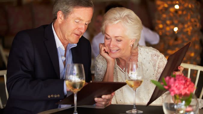 Senior Couple Choosing From Menu In Restaurant.