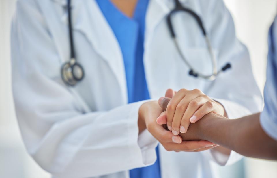 Doctor holding patient's hand.