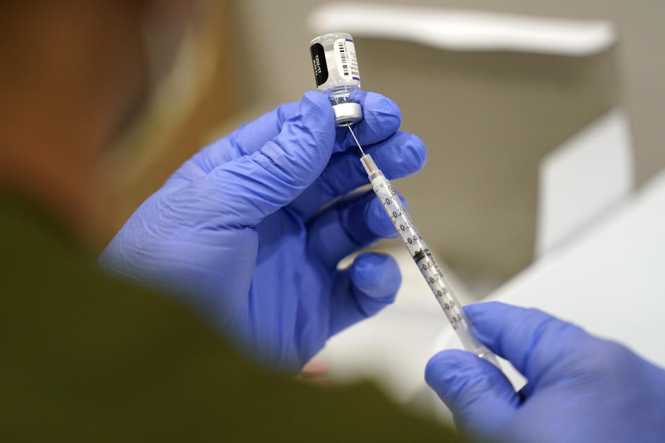 FILE - In this Oct. 5, 2021, file photo a healthcare worker fills a syringe with the Pfizer COVID-19 vaccine at Jackson Memorial Hospital in Miami. President Joe Biden’s most aggressive move yet to combat the COVID-19 pandemic is almost ready to see the light of day. The government is close to publishing the details of a new vaccination-or-testing rule covering more than 80 million Americans at companies with 100 or more workers. (AP Photo/Lynne Sladky, File)