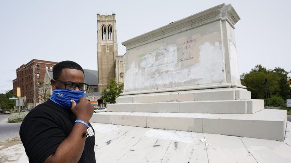 Devon Henry, owner of Henry Enterprises, adjusts his mask in front of the pedestal that used to hold the statue of Confederate General J.E.B Stuart during an interview Tuesday Sept. 15, 2020, in Richmond, Va. (AP Photo/Steve Helber)