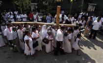 Catholics carry a holy cross at a street parade during a special Good Friday mass in Colombo, Sri Lanka. Holy Week is celebrated in many Christian traditions during the week before Easter.