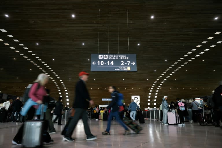 Unso pasajeros recorren un vestíbulo del aeropuerto parisino Roissy-Charles de Gaulle el 25 de abril de 2024 (Thomas Samson)