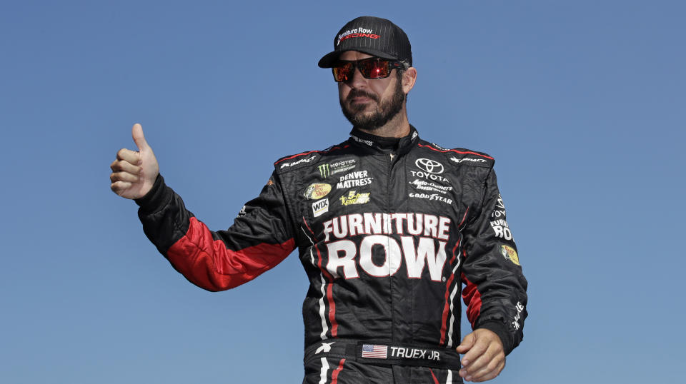 FILE - In this Sept. 24, 2017, file photo, Martin Truex Jr., the playoff point leader, flashes a thumb up as he is introduced prior to the NASCAR Cup Series 300 auto race at New Hampshire Motor Speedway in Loudon, N.H. Furniture Row Racing will cease operations at the end of this season, shutting its doors one year after Martin Truex Jr. won NASCAR’s championship driving for the maverick race team. Furniture Row is an anomaly in NASCAR in that it is a single-car team based in Denver, Colorado, far removed from the North Carolina hub. Team owner Barney Visser was a racing enthusiast with a vision when he launched the team in 2005 determined to do it his own way. But a lack of sponsorship for next season led Visser to make the “painful decision” to close the team. (AP Photo/Charles Krupa, File)