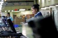 Migrant workers from Myanmar test the quality of monitors as they work on a TV assembly line at a factory in Bangkok