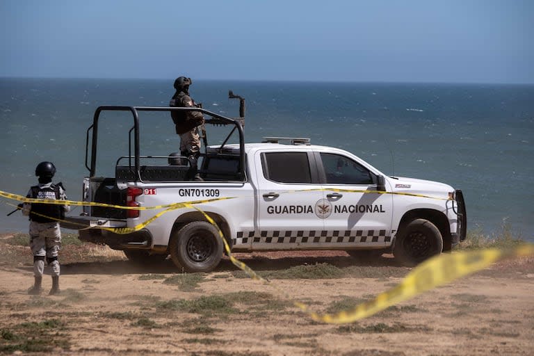 Vehículos de la Guardia Nacional custodian una búsqueda de investigación de los fiscales estatales en el sitio donde acampaban tres surfistas antes de desaparecer la semana pasada durante un viaje de surf, mientras continúa la investigación en El Faro, delegación de Santo Tomás en Ensenada, estado de Baja California, México