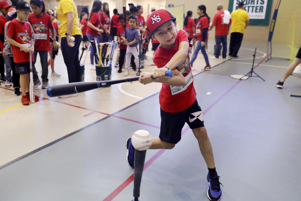 Kids test their batting skills during Sports Matter Day at the University of Houston, Saturday, Dec. 3, 2022, in Houston. (AP Photo/Michael Wyke)