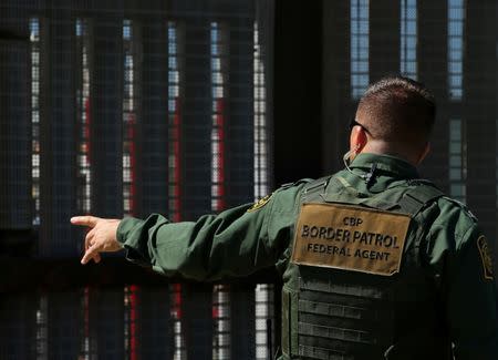 A U.S. Border patrol agent directs people near the fence with Mexico during a Children's Day event at Border Field State Park in San Diego, California, U.S., April 30, 2017. REUTERS/Mike Blake