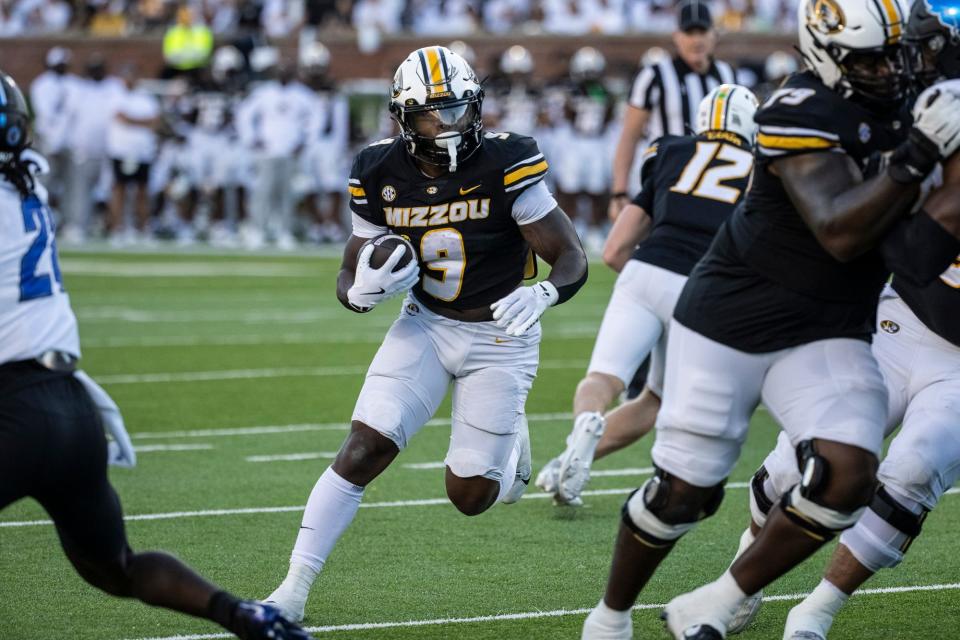 Missouri football running back Marcus Carroll (9) runs with the ball while right tackle Armand Membou, front right, blocks during the first half of the Tigers' game against the Buffalo Bulls on September 7, 2024 in Columbia, MO. Mathew Kirby.