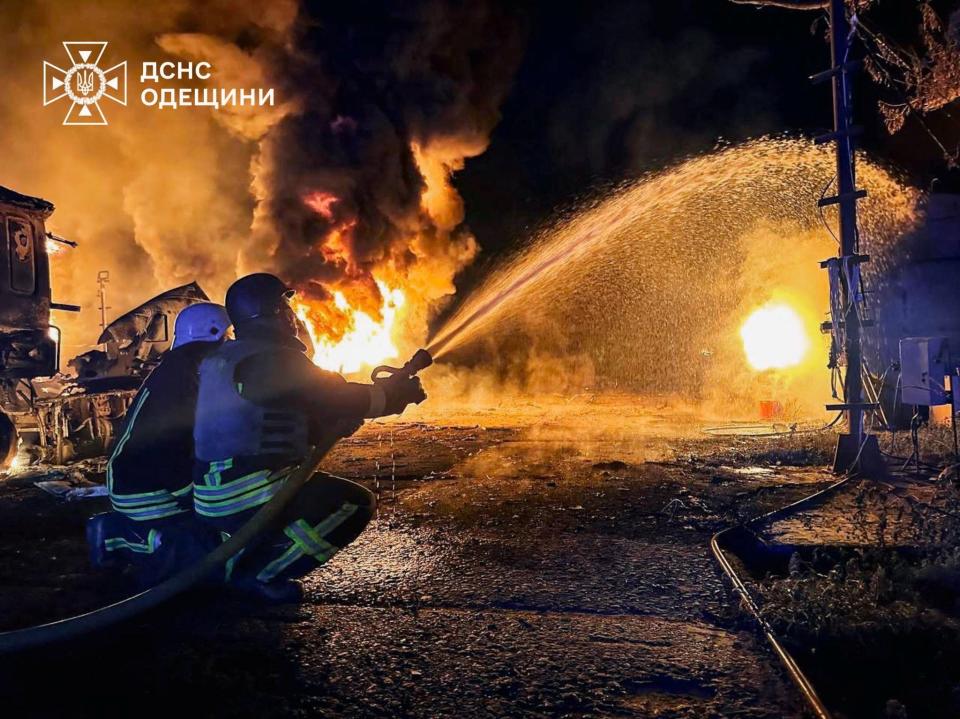 Members of emergency services use a water hose as flames and smoke rise in the aftermath of a Russian drone strike, amid Russia's invasion of Ukraine, in a location given as Izmail (via REUTERS)