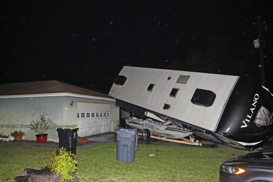 A camper rests on top of a boat trailer and the corner of a home as Tropical Storm Nestor passed the area on Saturday, Oct. 19, 2019 in Kathleen, Fla. Nestor was downgraded Saturday after it spawned a tornado that damaged several homes. (Luis Santana/Tampa Bay Times via AP)