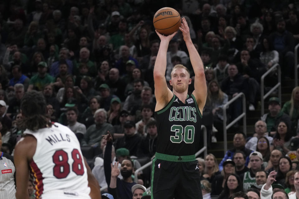 Boston Celtics forward Sam Hauser (30) takes a shot over Miami Heat guard Patty Mills (88) during the first half of Game 5 of an NBA basketball first-round playoff series, Wednesday, May 1, 2024, in Boston. (AP Photo/Charles Krupa)