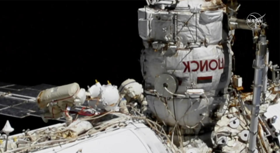 This photo provided by NASA shows Russian astronauts Commander Sergey Ryzhikov, left in red stripes, and Sergey Kud-Sverchkov on a spacewalk outside of the International Space Station on Wednesday, Nov. 18, 2020, as they prepare for next year's arrival of a long-delayed lab. (NASA via AP)