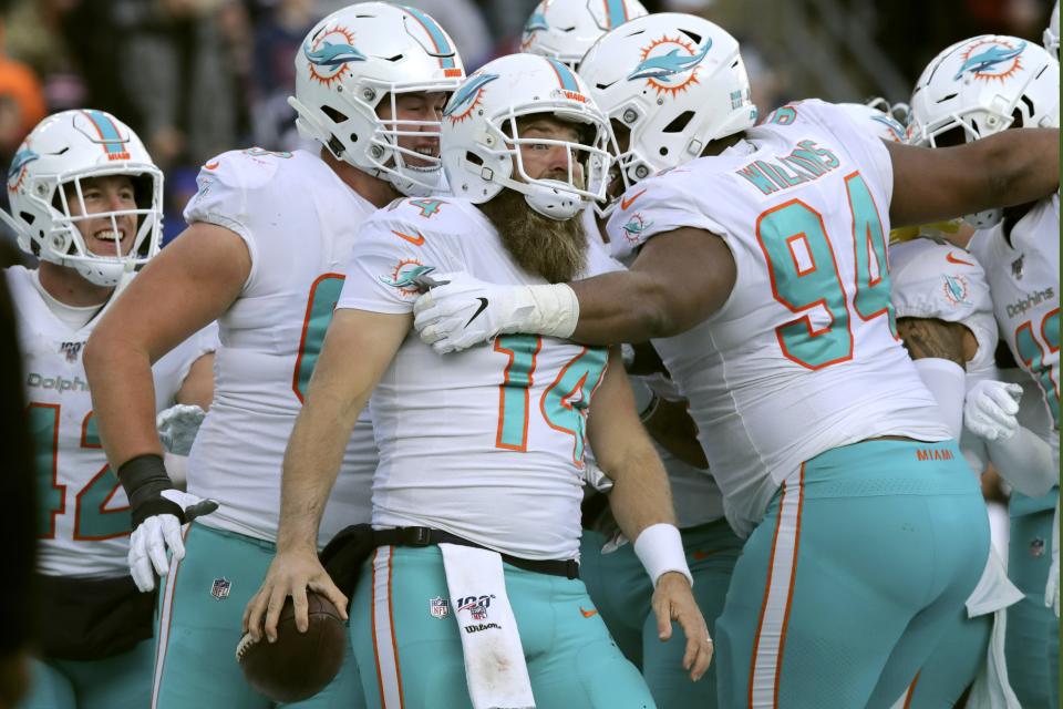 Miami Dolphins quarterback Ryan Fitzpatrick, center, celebrates his touchdown run with teammates in the second half of an NFL football game against the New England Patriots, Sunday, Dec. 29, 2019, in Foxborough, Mass. (AP Photo/Charles Krupa)