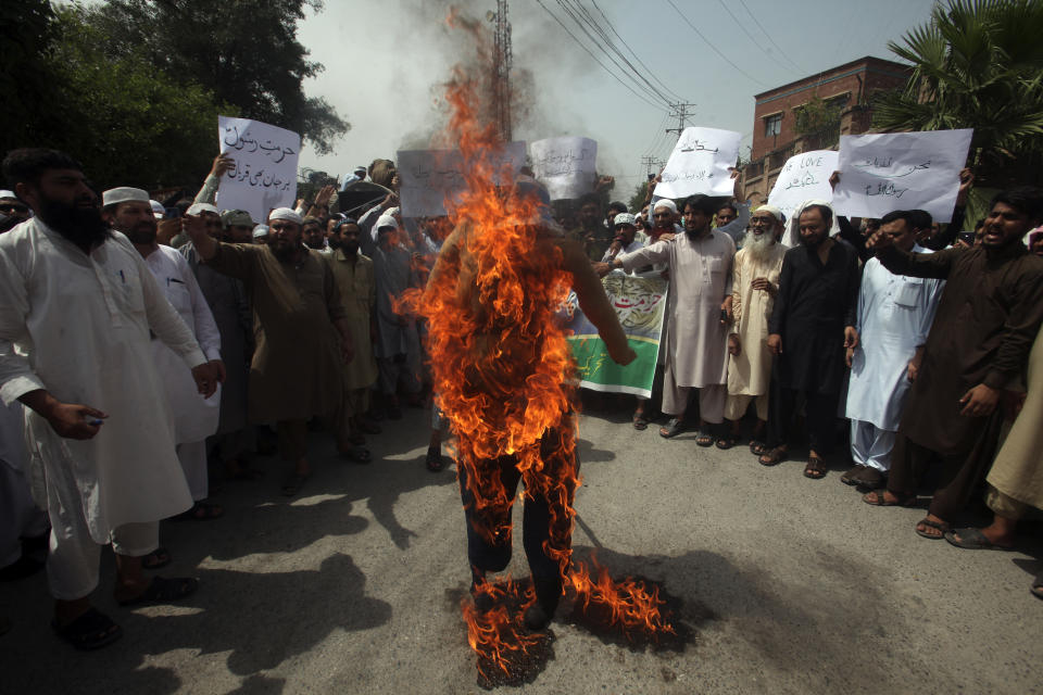 Pakistani people burn an effigy depicting India's Prime Minister Narendra Modi during a demonstration to condemn derogatory references to Islam and the Prophet Muhammad recently made by Nupur Sharma, a spokesperson of the governing Indian Hindu nationalist party, Friday, June 10, 2022, in Peshawar, Pakistan. (AP Photo/Mohammad Sajjad)
