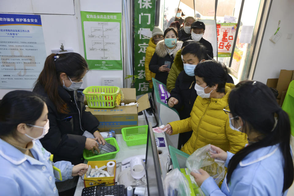 People line up to buy face masks at a drug store in Nanjing in eastern China's Jiangsu Province, Wednesday, Jan. 29, 2020. Countries began evacuating their citizens Wednesday from the Chinese city hardest-hit by an outbreak of a new virus that infected more than 6,000 on the mainland and abroad. (Chinatopix via AP)