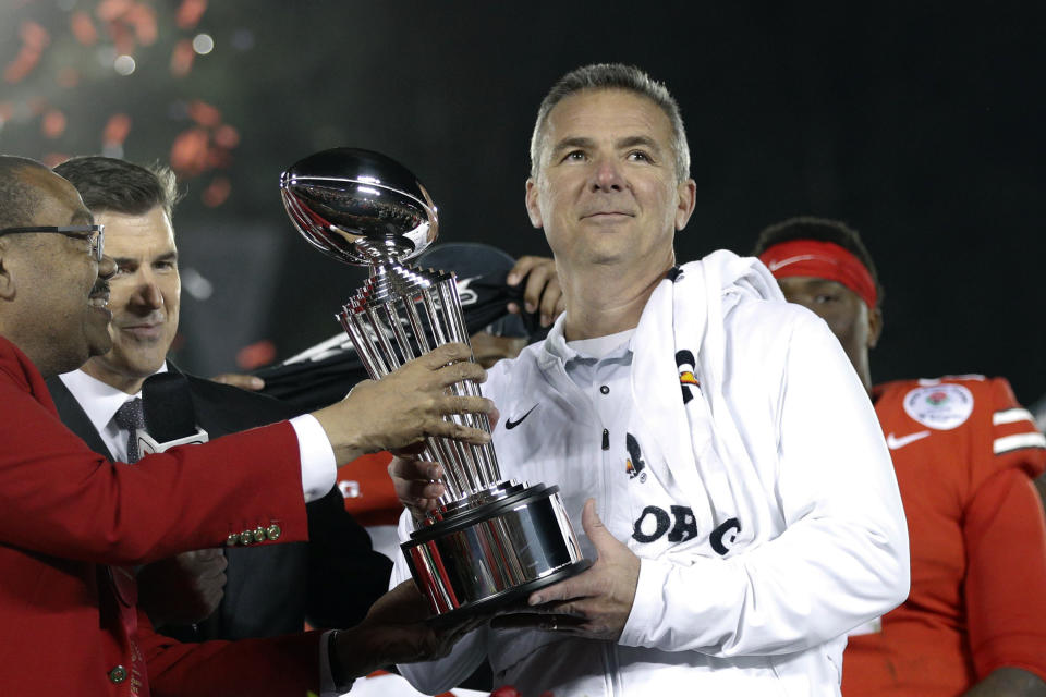 FILE - Ohio State coach Urban Meyer, right, holds the trophy after the team's 28-23 win over Washington in the Rose Bowl NCAA college football game in Pasadena, Calif., in a Tuesday, Jan. 1, 2019, file photo. A person familiar with the search says Urban Meyer and the Jacksonville Jaguars are working toward finalizing a deal to make him the team's next head coach. The person spoke to The Associated Press on the condition of anonymity Thursday, Jan. 14, 2021, because a formal agreement was not yet in place. (AP Photo/Jae C. Hong, File)