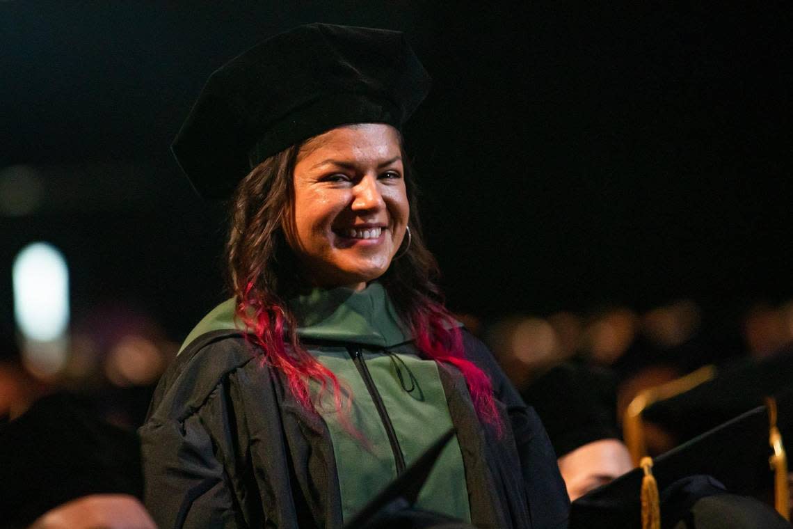 Aisha Visram stands as her name is called during Florida International University’s commencement ceremonies at the Ocean Bank Convocation Center at the Modesto A. Maidique Campus in Miami on Tuesday, Dec. 13, 2022.