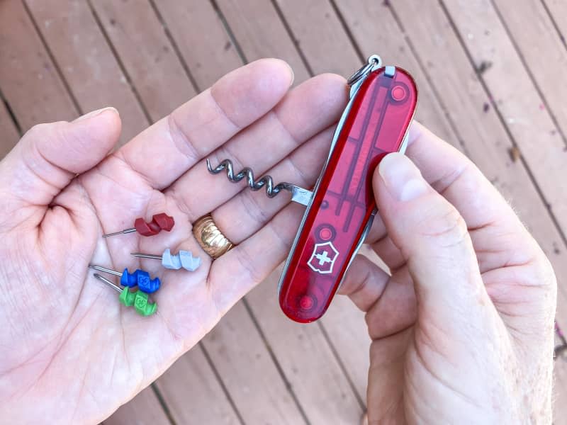 Close-up look at hands holding a Swiss Army Knife and the corresponding mini tool attachments