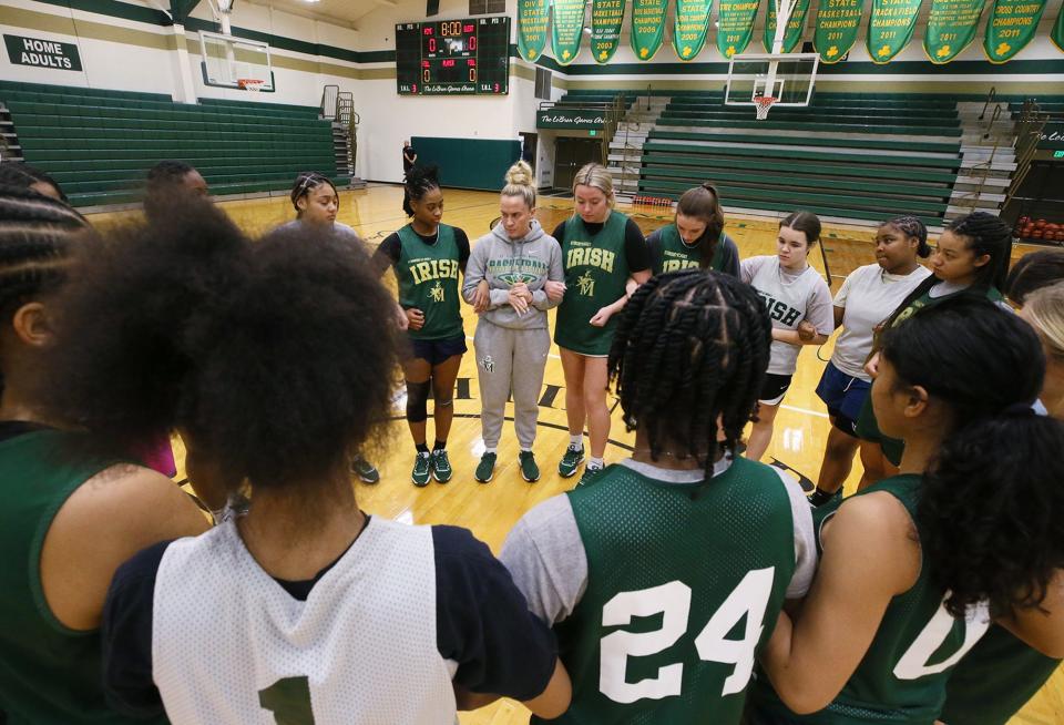 Head coach Carley Whitney gathers her St. Vincent-St. Mary girls basketball team prior to a practice earlier this season.