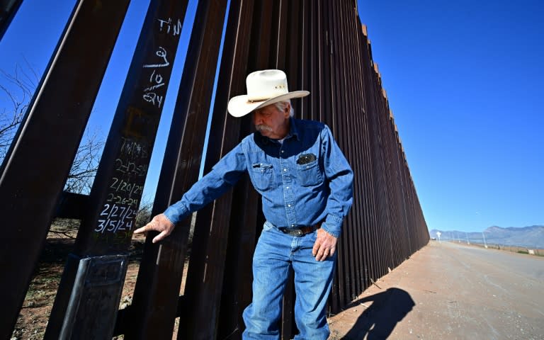 Cattle rancher John Ladd points to dates written on a lower section of the thirty-foot tall US-Mexico border wall marking repairs made after the wall was compromised by migrants crossing into his land from Mexico (Frederic J. BROWN)