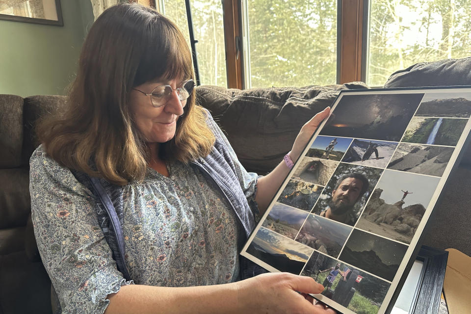 Barbara Roma, the mother of Chris Roma who died hiking, looks at family photos of her son at her home in Thornton, N.H., in the heart of the White Mountains, Friday, Jan. 19, 2024. Chris Roma, the expert hiker who completed the "Triple Crown" of challenging cross-country trails was found dead on Mount Guyot during a hike in brutal weather conditions. (AP Photo/Nick Perry)