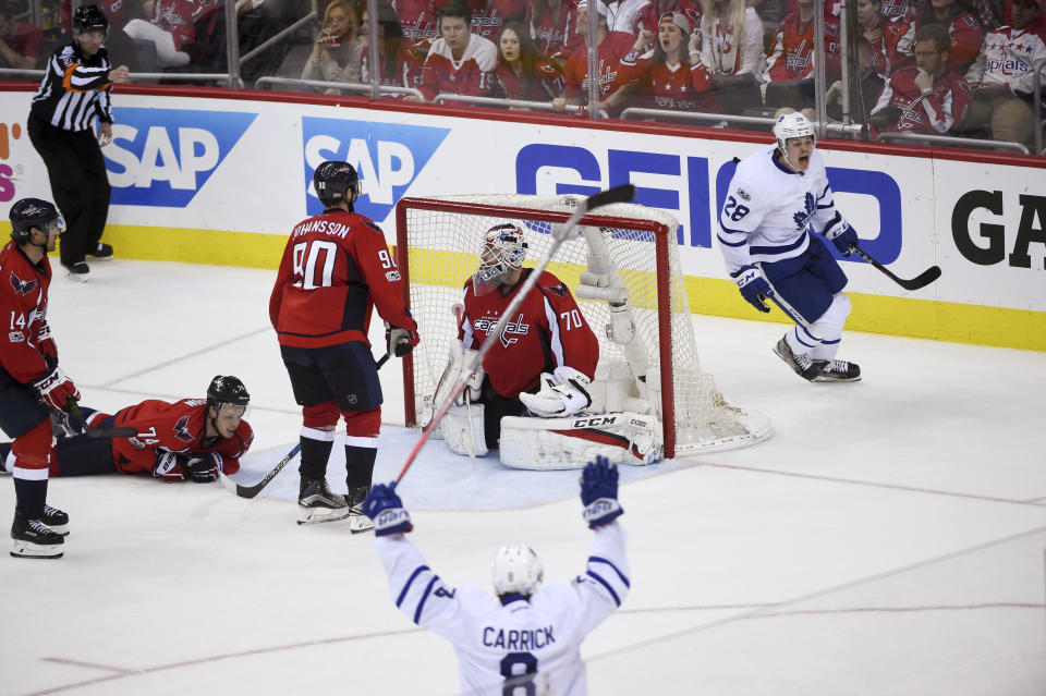 Toronto Maple Leafs right wing Kasperi Kapanen, right rear, of Finland celebrates his goal as Washington Capitals goalie Braden Holtby (70) remains in the net, watched by Washington right wing Justin Williams (14), defenseman John Carlson (74) and left wing Marcus Johansson (90) and Toronto defenseman Connor Carrick (8) during the second overtime in Game 2 of an NHL Stanley Cup first round playoff series in Washington, Saturday, April 15, 2017. The Maple Leafs won 4-3. (AP Photo/Molly Riley)