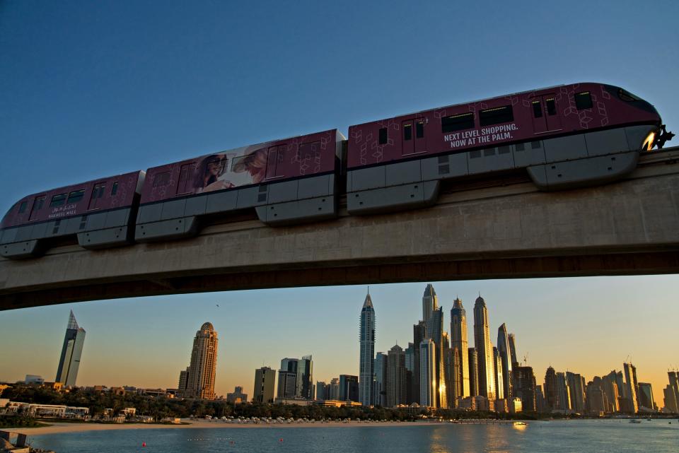 FILE - A monorail on the Palm Jumeirah passes on a track above the skyline of the Dubai Marina in Dubai, United Arab Emirates, on Dec. 21, 2019. The FIFA World Cup may be bringing as many as 1.2 million fans to Qatar, but the nearby flashy emirate of Dubai is also looking to cash in on the major sports tournament taking place just a short flight away. (AP Photo/Jon Gambrell, File)