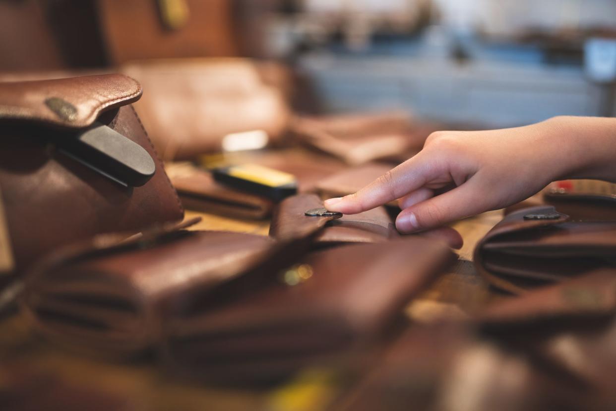 Child's hand choosing a leather wallet
