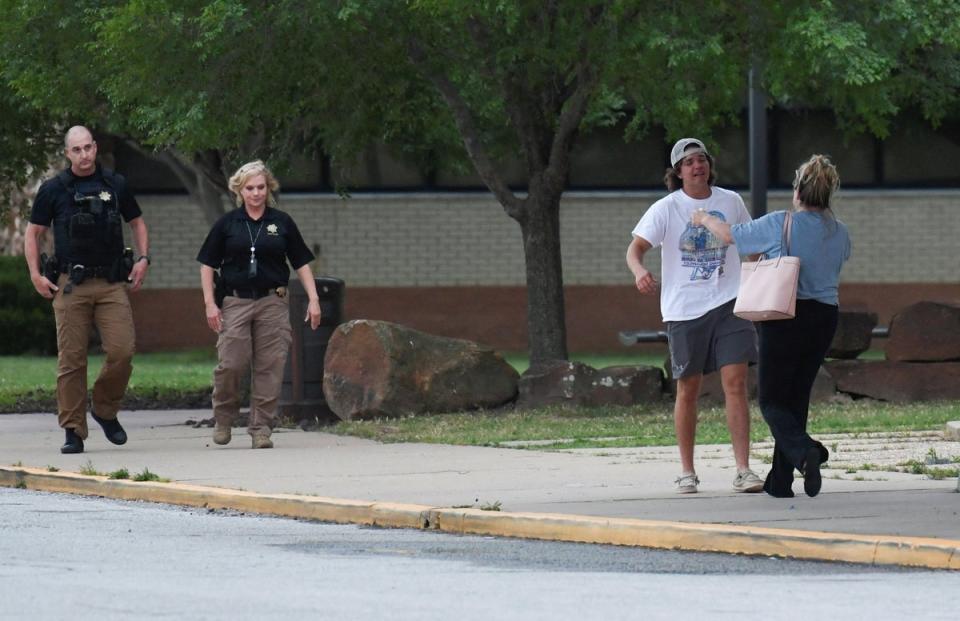 People meet at the reunion location, Memorial High School after a shooting at the Saint Francis hospital campus, in Tulsa, Oklahoma (Reuters)
