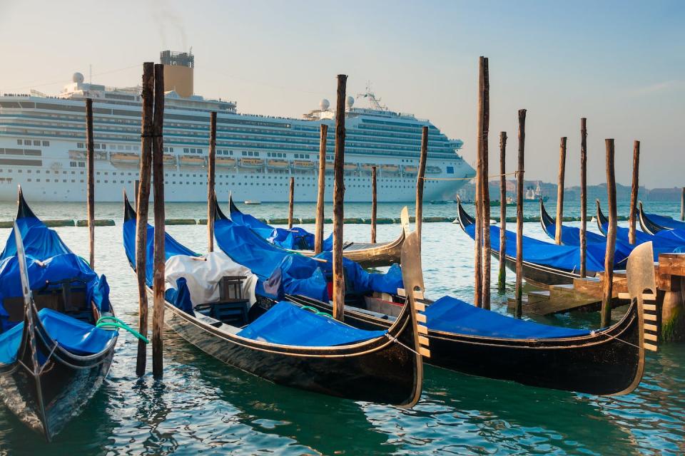 En 2022, Venise a interdit aux grands navires de croisière d’accoster dans ses eaux. <a href="https://www.shutterstock.com/image-photo/gondolas-on-background-huge-cruise-ship-243221659" rel="nofollow noopener" target="_blank" data-ylk="slk:Ugis Riba/Shutterstock;elm:context_link;itc:0;sec:content-canvas" class="link ">Ugis Riba/Shutterstock</a>