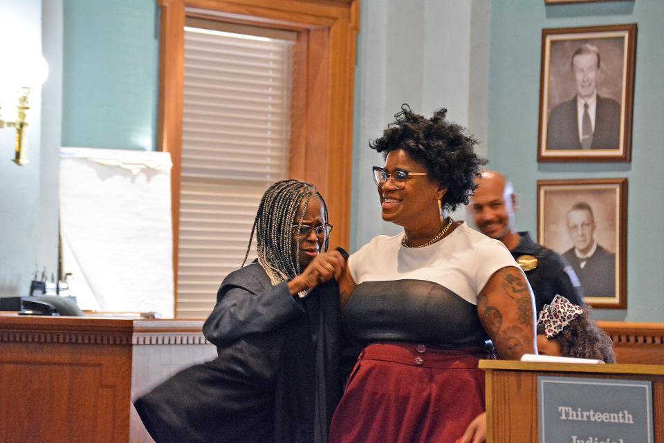 Rebecca Franklin, mother of Kayla Jackson-Williams, helps her daughter put on judge's robes Friday in a swearing-in ceremony at the Boone County Courthouse at which she is officially made a judge for the 13th judicial circuit. 
